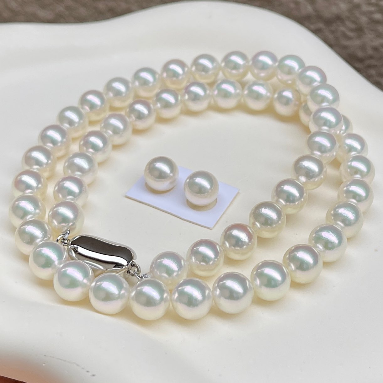 無調色アコヤ真珠ネックレス8.0-8.5㎜総研厚巻き良質真珠ハイクラスセットを斜め前から見ている