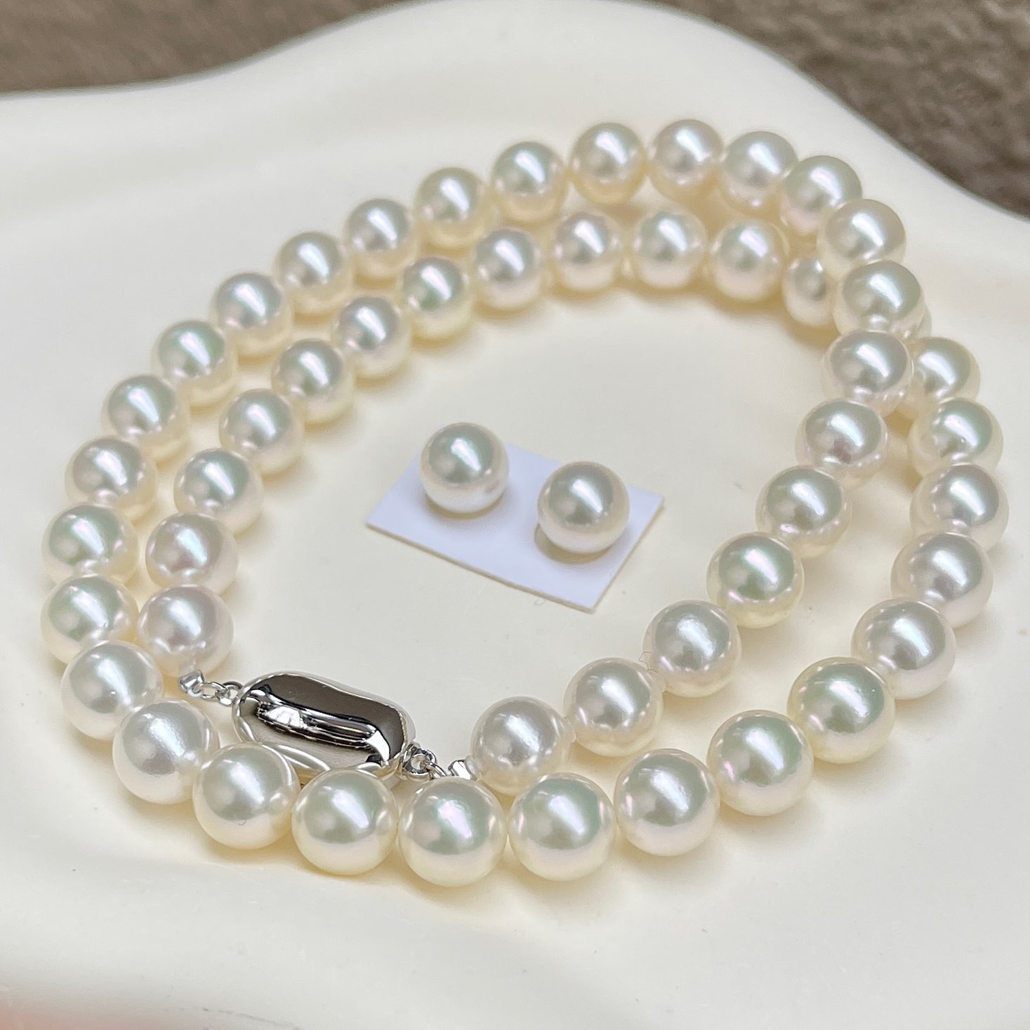 あこや真珠ネックレス越物無調色ハイクラスセット8.0-8.5㎜サイズ総研厚巻き良質真珠を斜め前から見ている